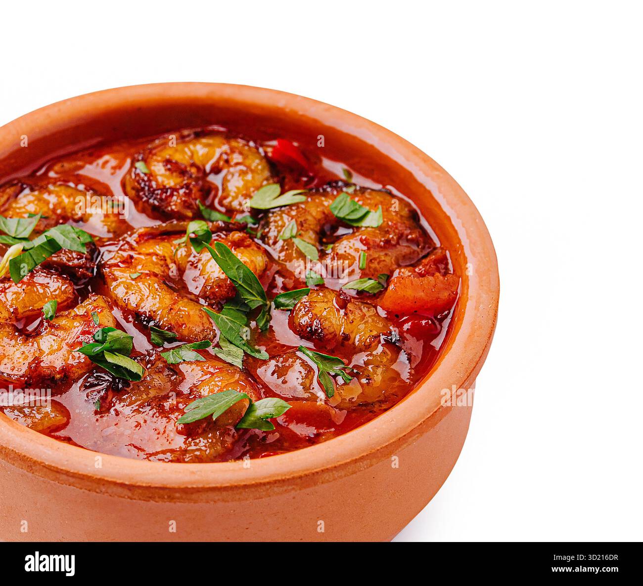 Delizioso piatto di gamberi in una pentola di argilla guarnita con erbe e spezie fresche Foto Stock