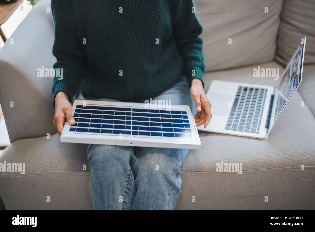 Donna asiatica che impara a conoscere le energie rinnovabili il controllo remoto dell'energia solare nella sua casa e l'installazione di pannelli solari sostenibili technolo Foto Stock