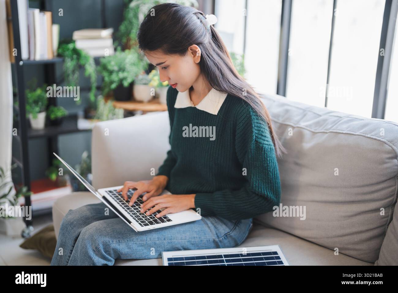 Il proprietario di casa installa sistemi di energia solare nella sua casa donna asiatica che impara a conoscere la tecnologia sostenibile Foto Stock