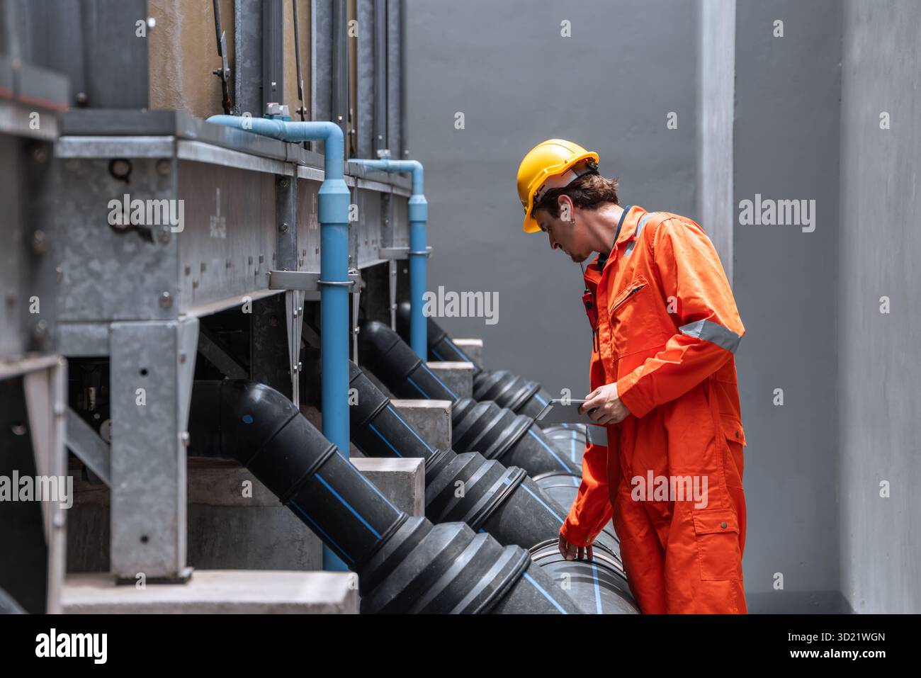 Tubo idraulico professionale, ingegnere del sistema di raffreddamento dell'acqua, uomo di lavoro controllo sistema di tubazioni dell'acqua di grandi dimensioni. Foto Stock