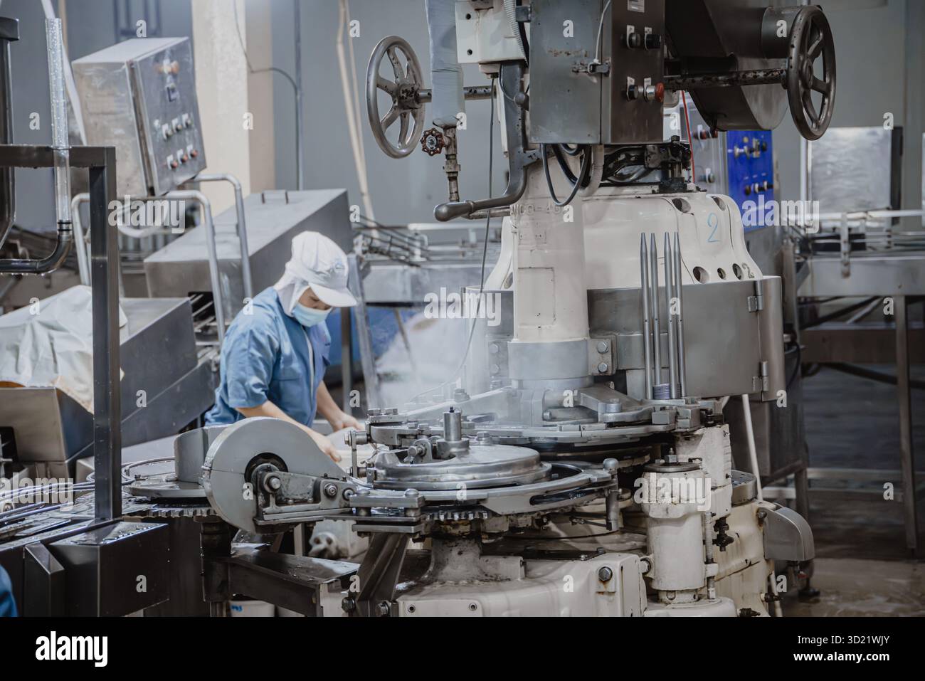 Fabbrica silenziosa, pochi operai che puliscono la linea di produzione trasportano il nastro si preparano a chiudere la fabbrica di alimenti Foto Stock