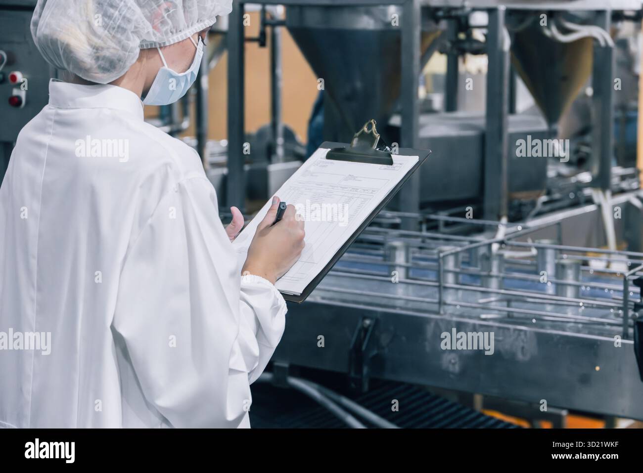addetto all'igiene dell'industria delle conserve alimentari presso il nastro trasportatore, elenco di controllo della fabbrica di alimenti in scatola, team dell'ispettore dell'igiene Foto Stock