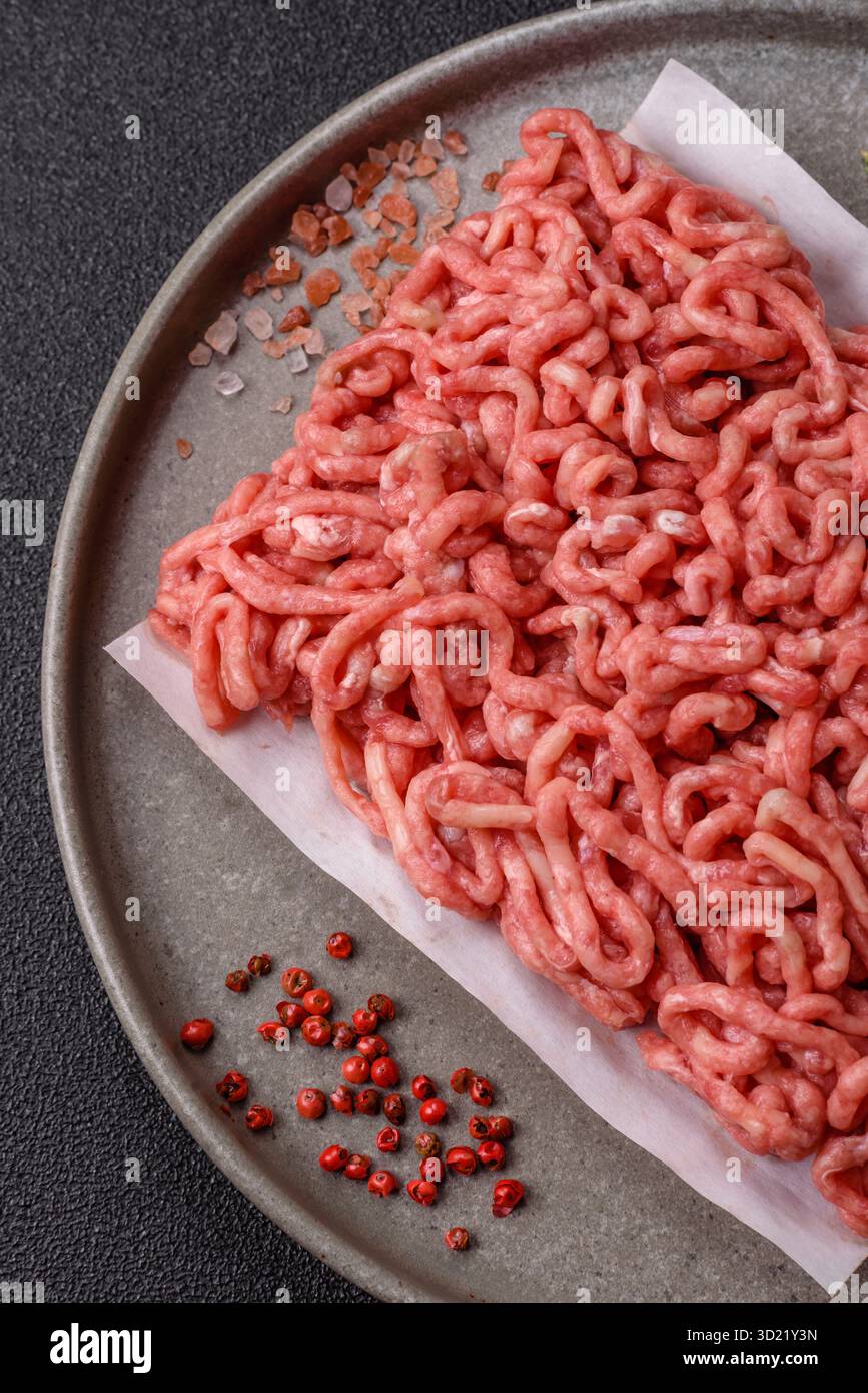 Carne macinata cruda o maiale come ingrediente per gli hamburger. Carne macinata cruda per cucinare a casa Foto Stock