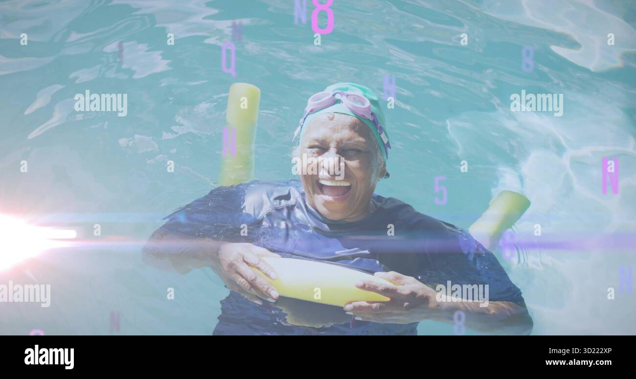 Nuotatore senior galleggiante che tiene spaghetti gialli nella piscina all'aperto, indossa un berretto e occhiali di protezione rosa Foto Stock
