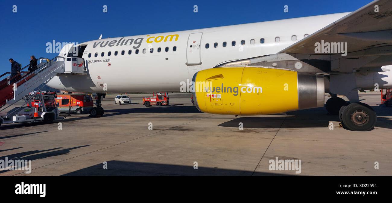 I passeggeri che salgono a bordo di un aeroplano regionale bianco sull'asfalto dell'aeroporto, preparandosi per la partenza sotto un cielo azzurro Foto Stock