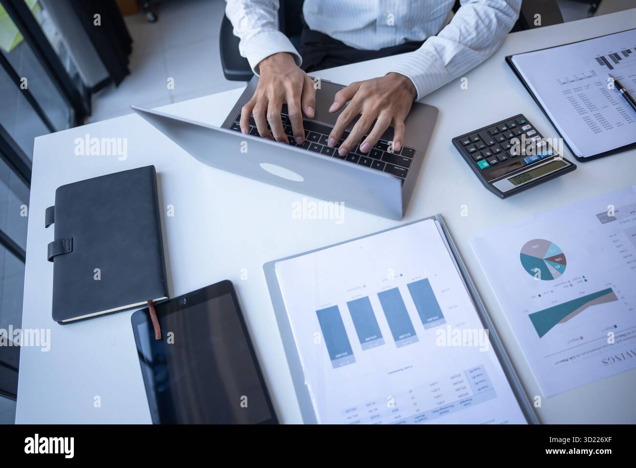 Uomo d'affari di successo che utilizza un notebook nell'ufficio moderno. Foto Stock