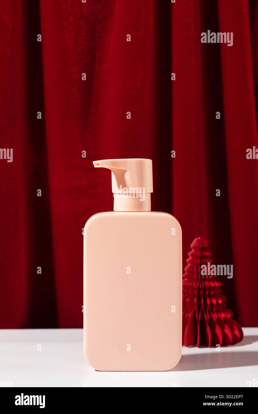 Biberon rosa con albero di Natale di carta vicino alla tenda Foto Stock