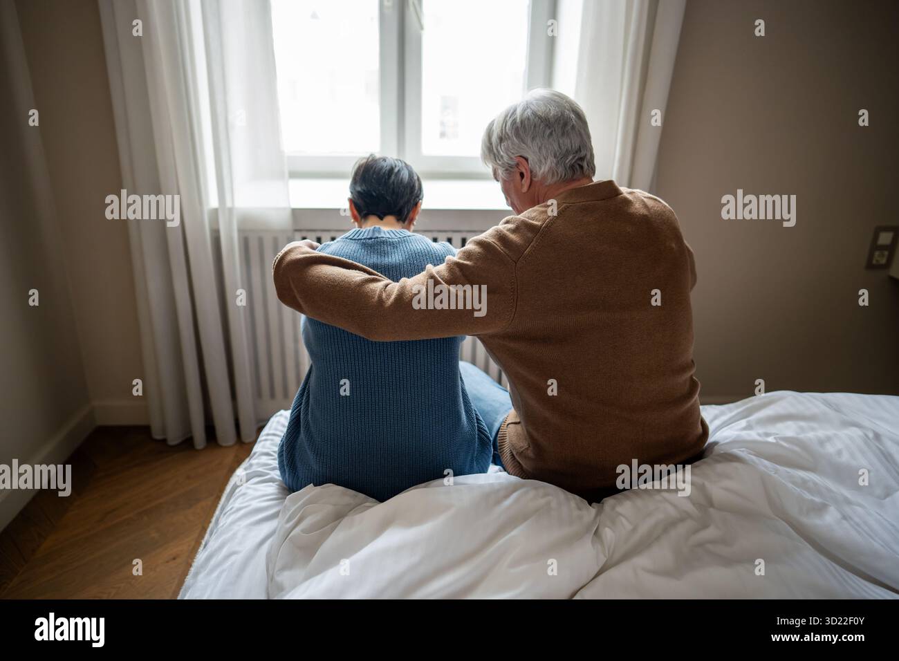 Perdita in una famiglia anziana, la coppia che abbraccia come uomo conforta la donna in lutto, fornendo supporto emotivo Foto Stock