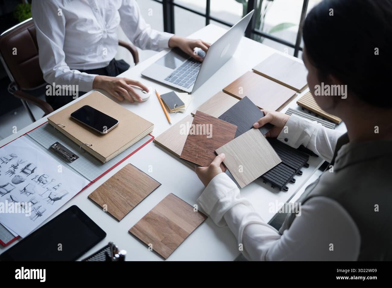 Designer di interni che presenta campioni di materiali in legno ecocompatibili per un arredamento sostenibile Foto Stock