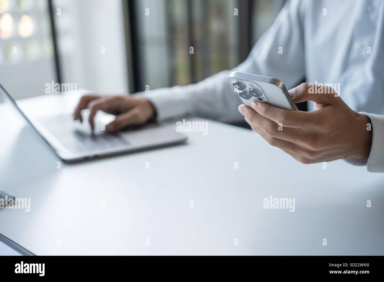 Uomo d'affari di successo che utilizza lo smartphone durante il lavoro in ufficio Foto Stock