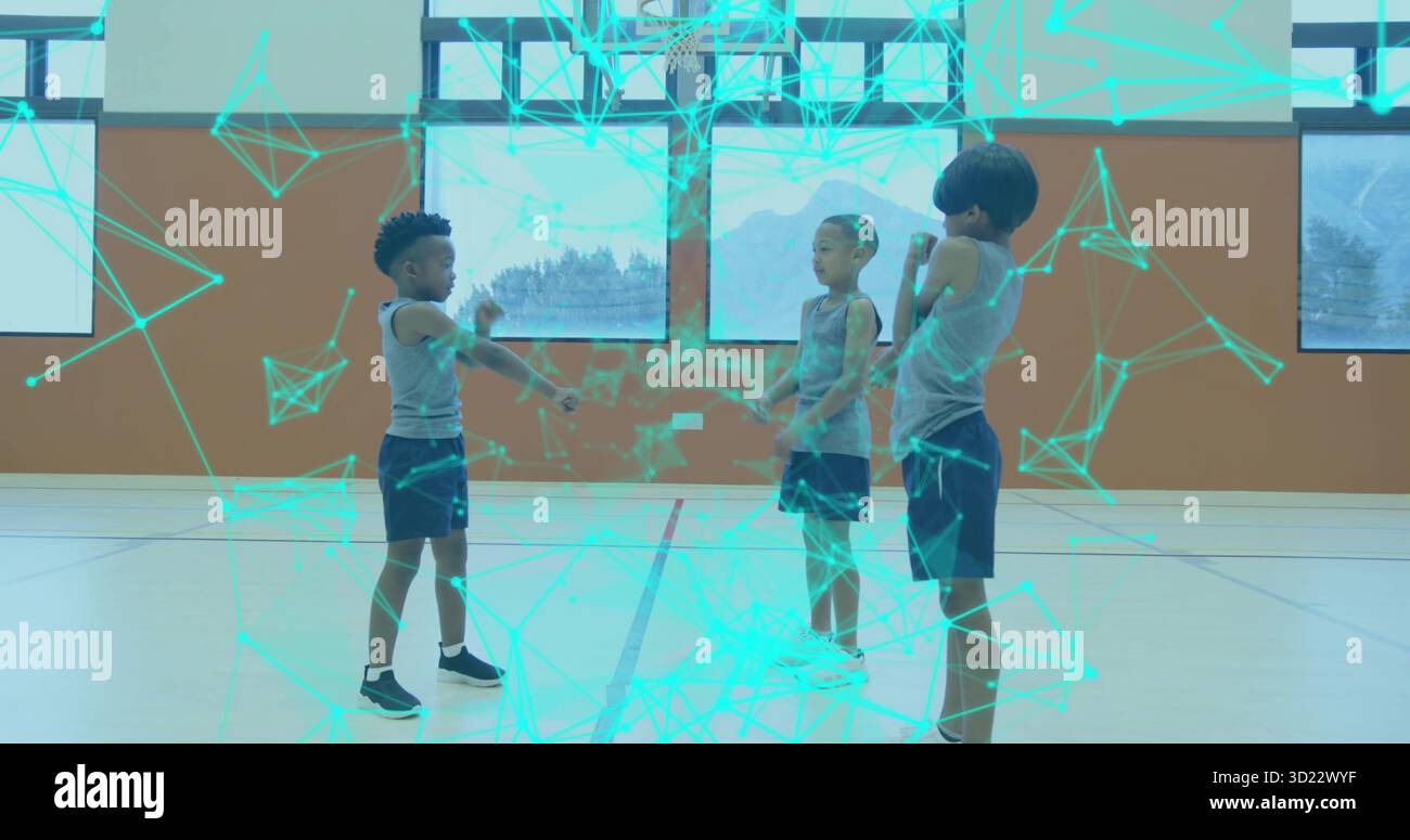 I ragazzi che indossano abbigliamento sportivo giocano a mano nella palestra scolastica, con canestro da basket e rivestimento olografico Foto Stock