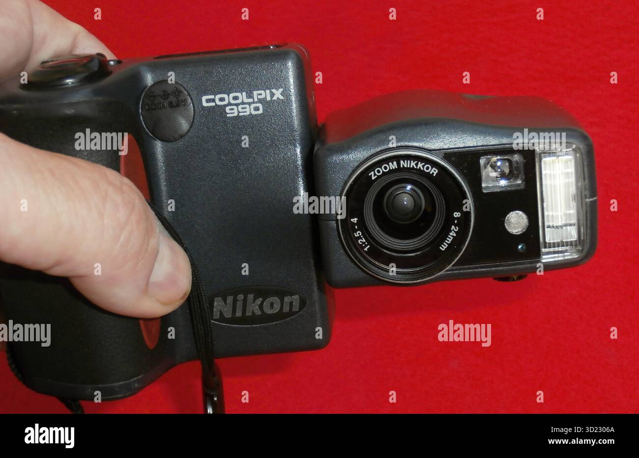 Fotografo che mette a confronto due fotocamere digitali Nikon Coolpix Foto Stock