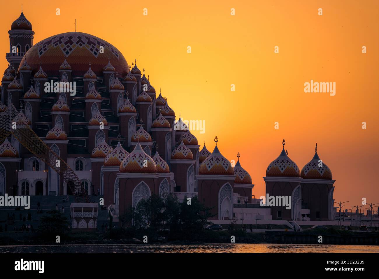 Splendida moschea con cupole ornate che si stagliano contro un cielo arancione al tramonto. Makassar, Sulawesi, Indonesia Foto Stock