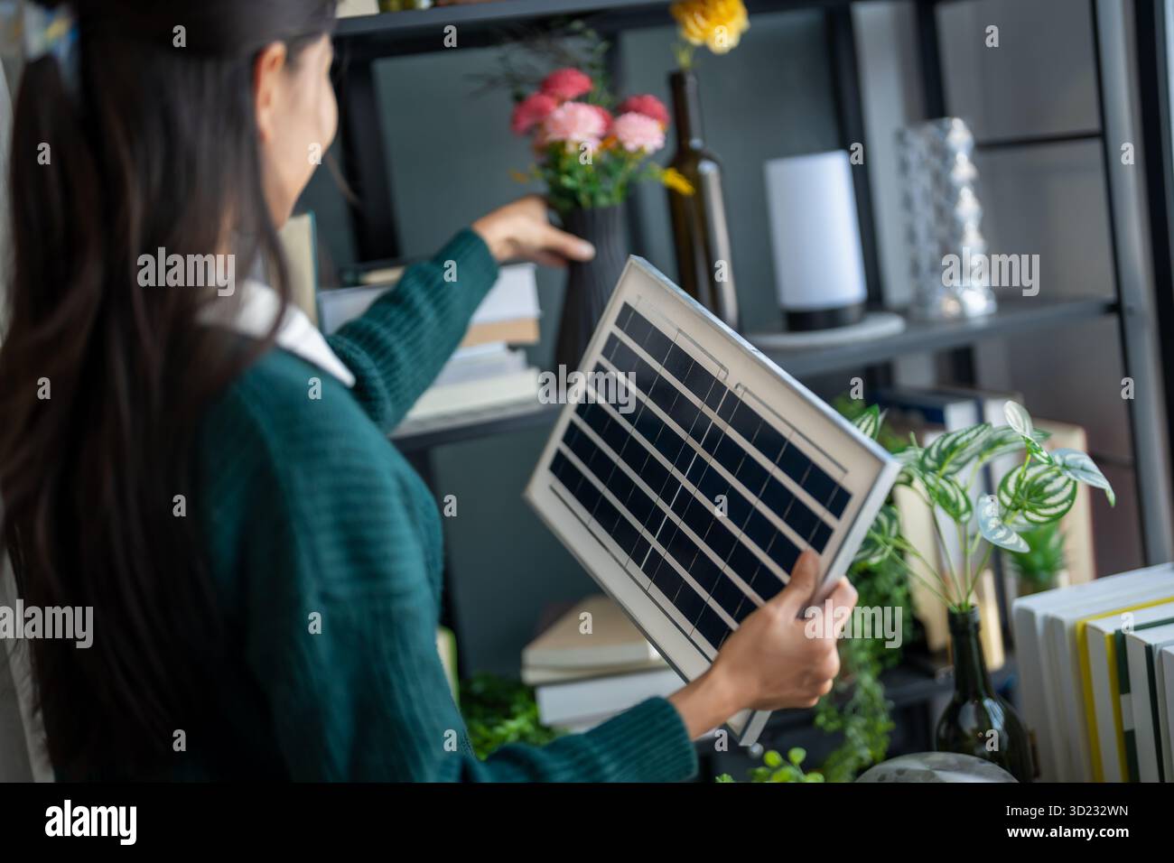 Il proprietario di casa installa sistemi di energia solare nella sua casa donna asiatica che impara a conoscere la tecnologia sostenibile Foto Stock