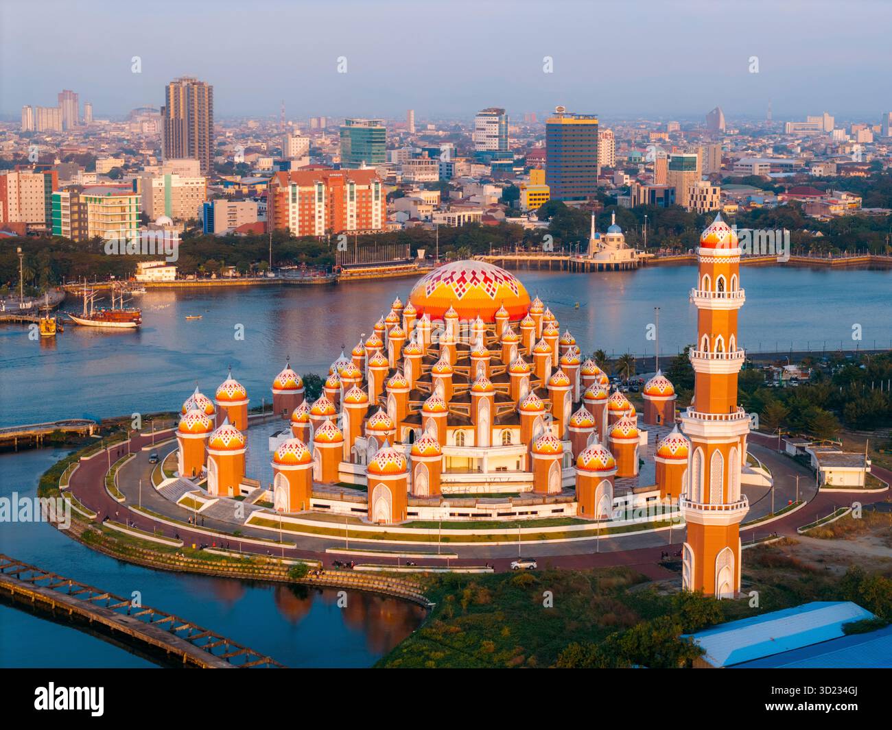 Splendida cupola della moschea con lo skyline della città e il fiume al tramonto, vivace e architettonicamente intricata. 99 Domes Mosque, Makassar, Sulawesi meridionale, Indonesia Foto Stock