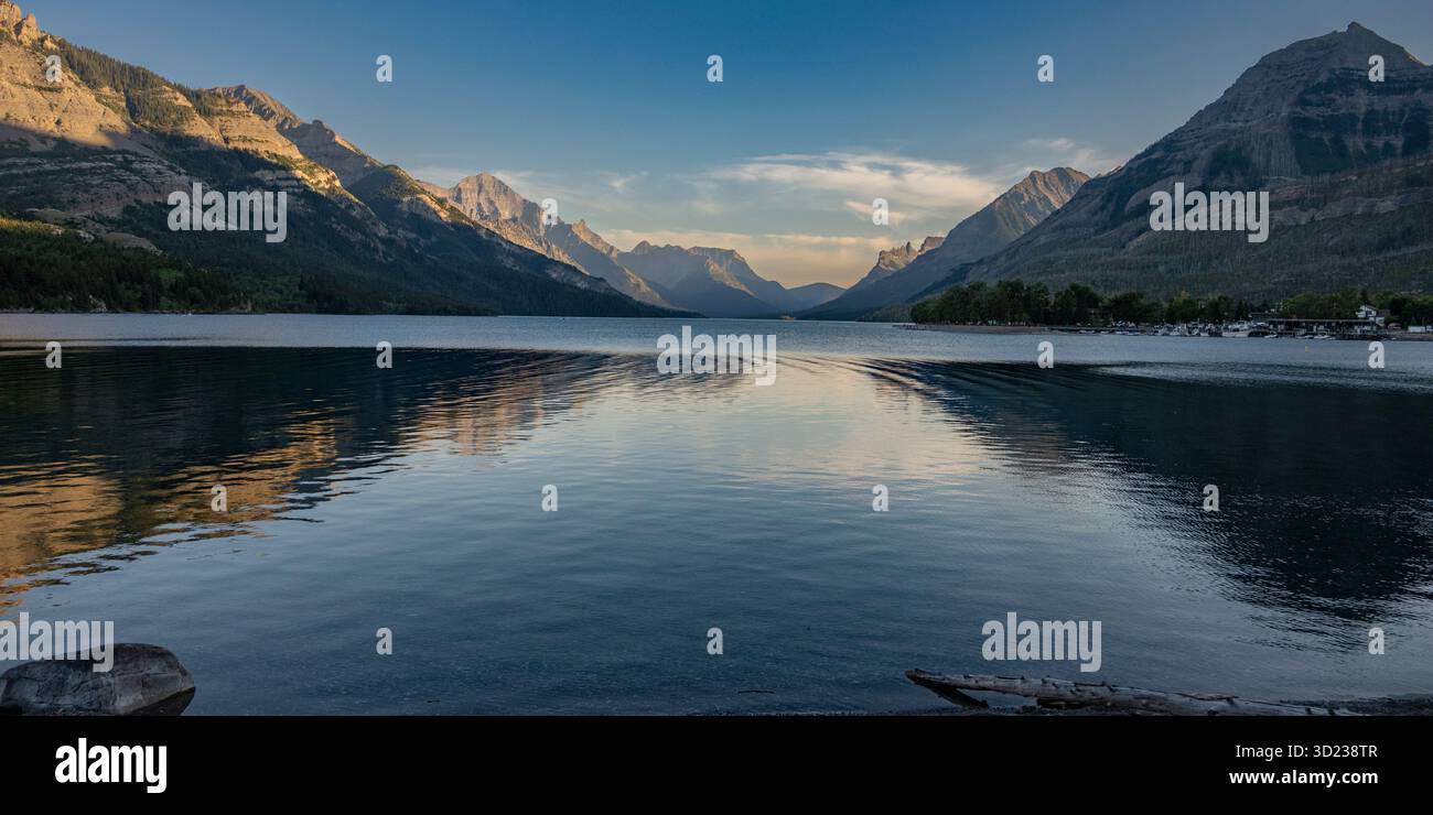 Tranquillo paesaggio montano con lago calmo e cielo azzurro al tramonto. Waterton Park, Alberta, Canada Foto Stock