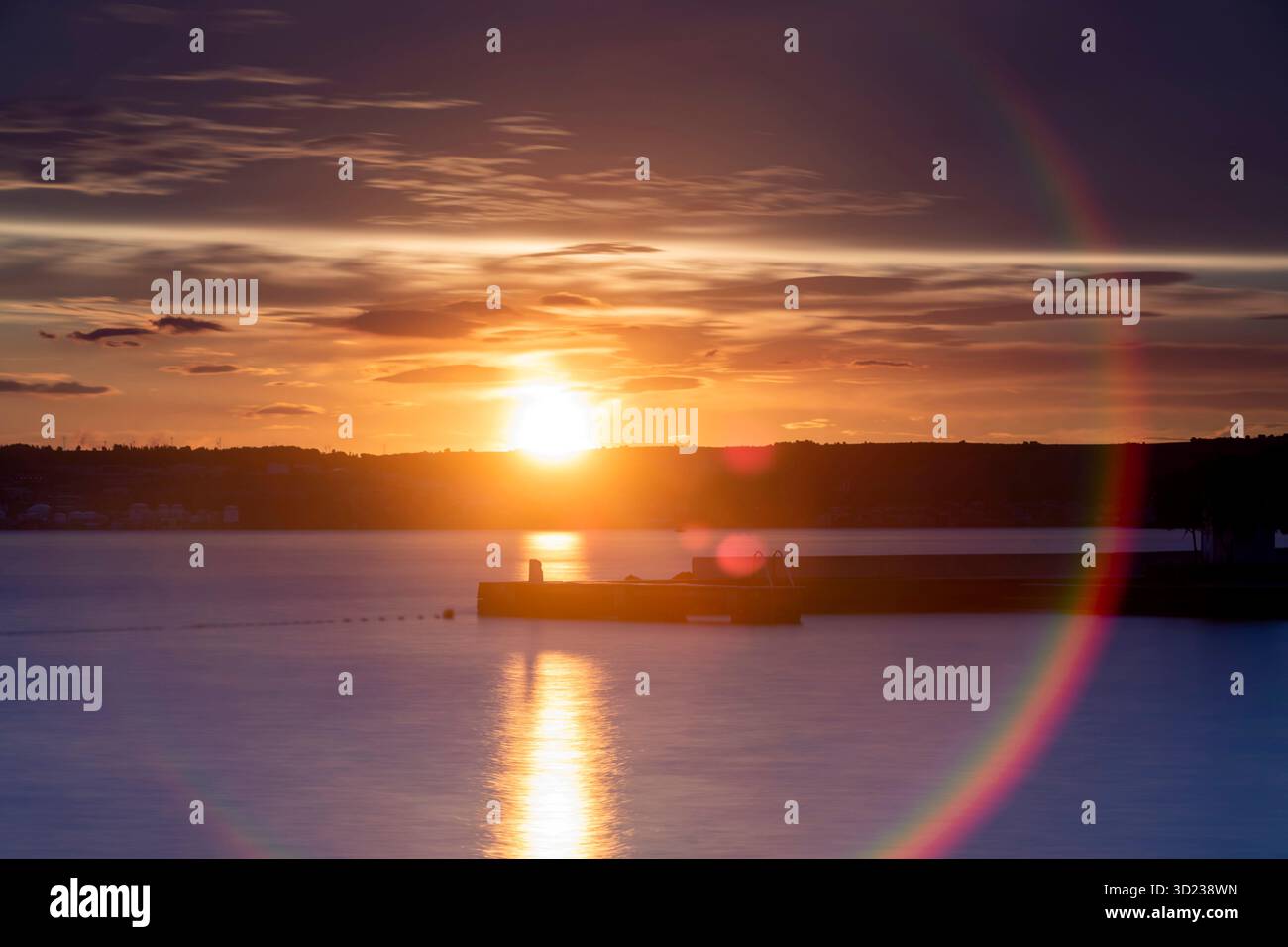 Uno splendido tramonto proietta colori vivaci su un calmo corpo d'acqua con un molo sagomato, Zara, Croazia. Foto Stock