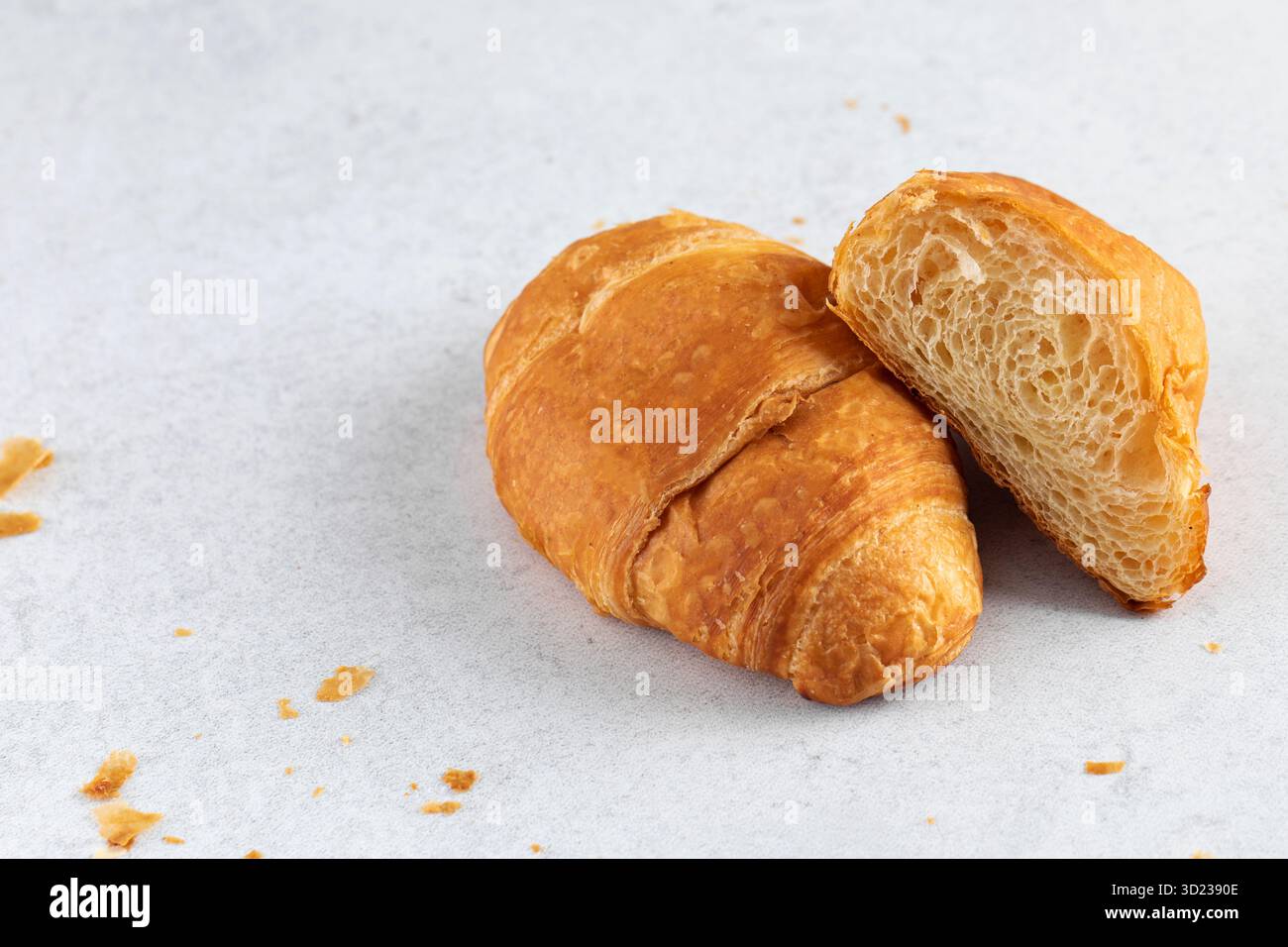 Croissant freschi su sfondo grigio. Colazione francese. Copia spazio Foto Stock