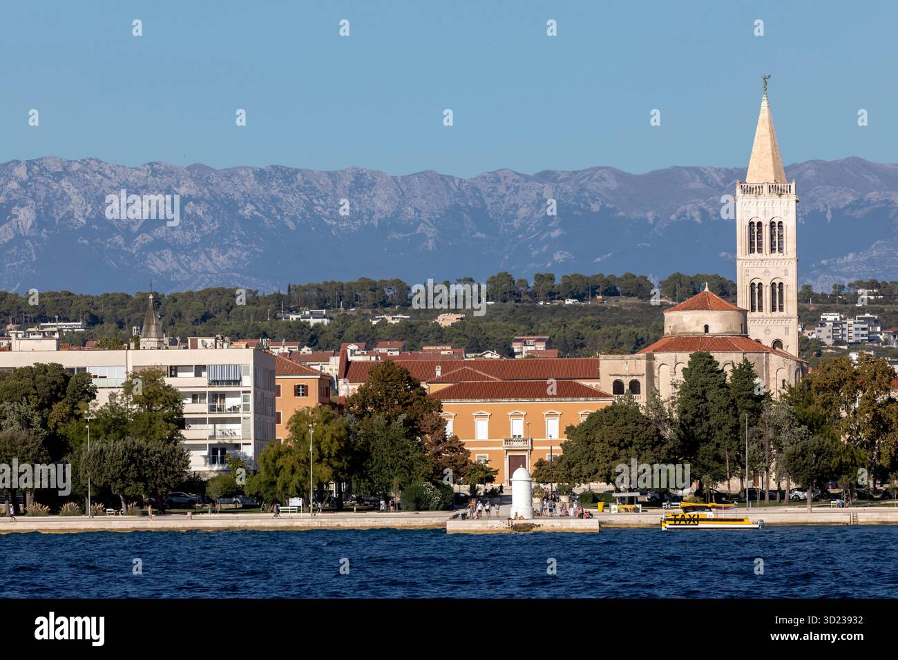Città costiera di Zara con edifici storici, alberi e montagne sotto un cielo azzurro, Croazia. Foto Stock
