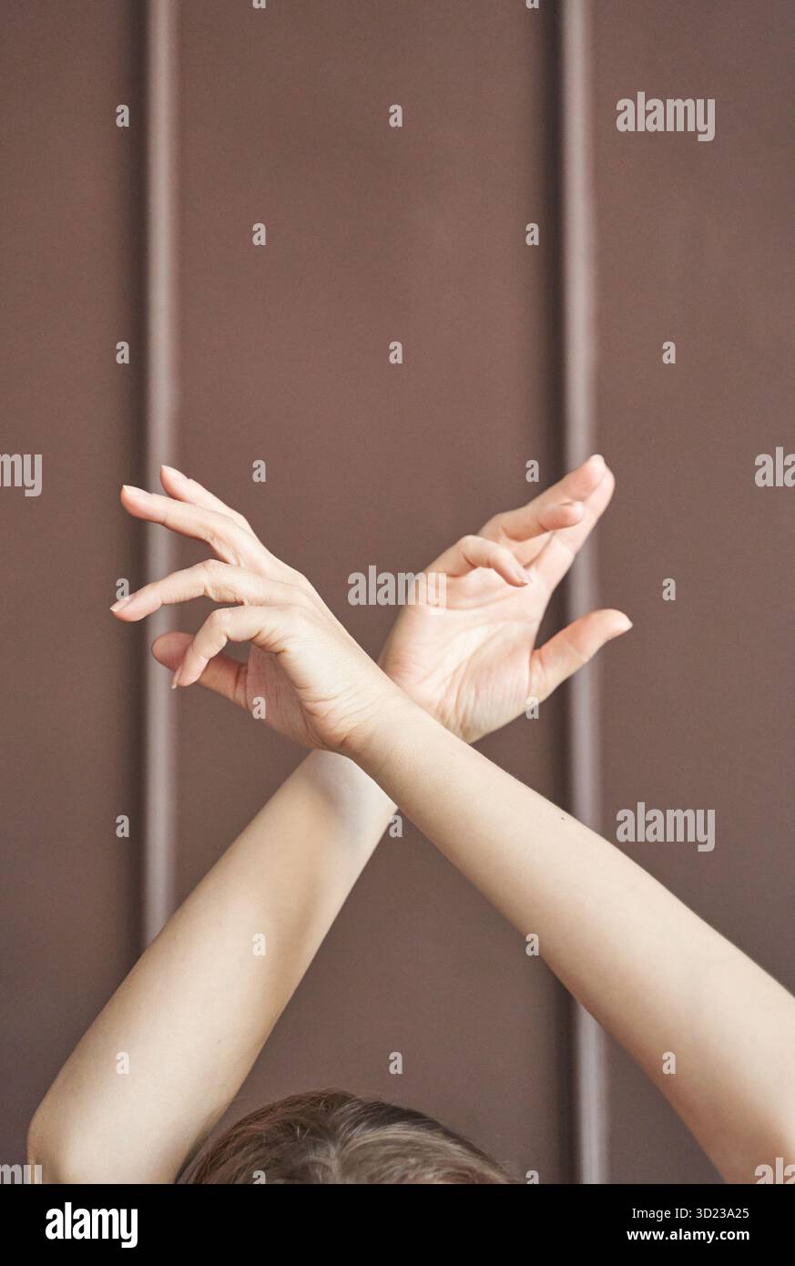 Mani adulte caucasiche in gesto espressivo su sfondo marrone Foto Stock