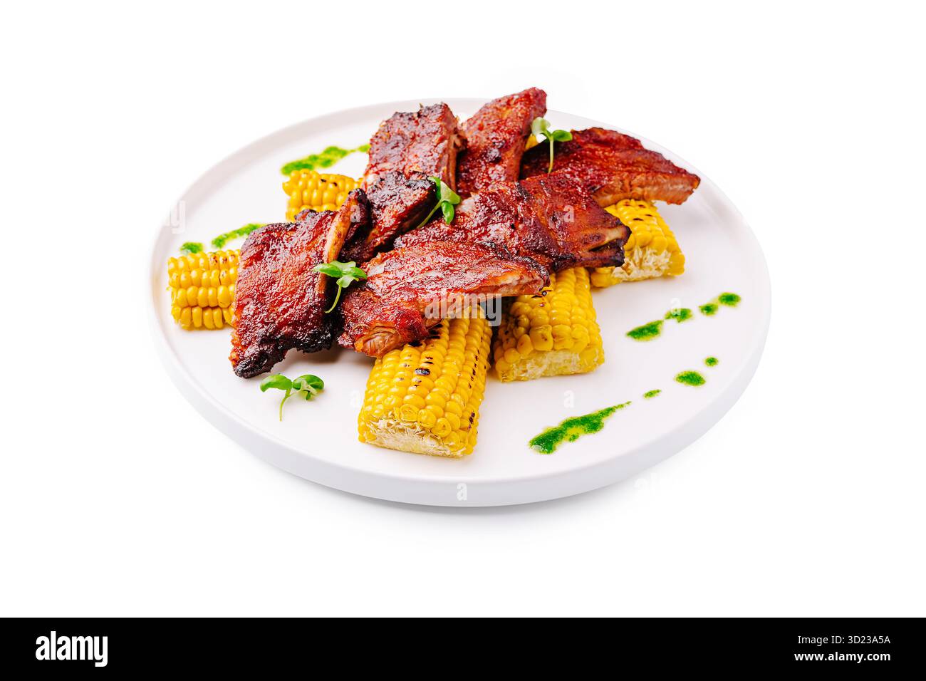 Costolette alla griglia servite con mais dolce e salsa verde per un pasto estivo Foto Stock