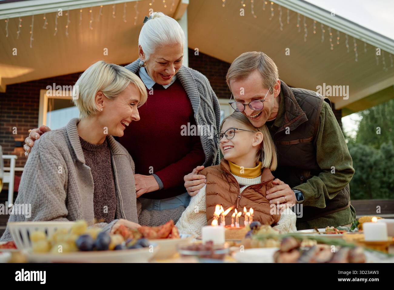 Famiglia caucasica che celebra il compleanno all'aperto sorridendo e interagendo insieme Foto Stock