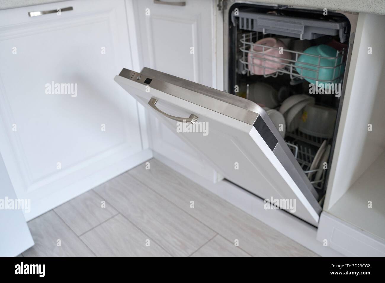 Lavastoviglie a vista con piatti puliti nella moderna cucina con pavimento in legno Foto Stock