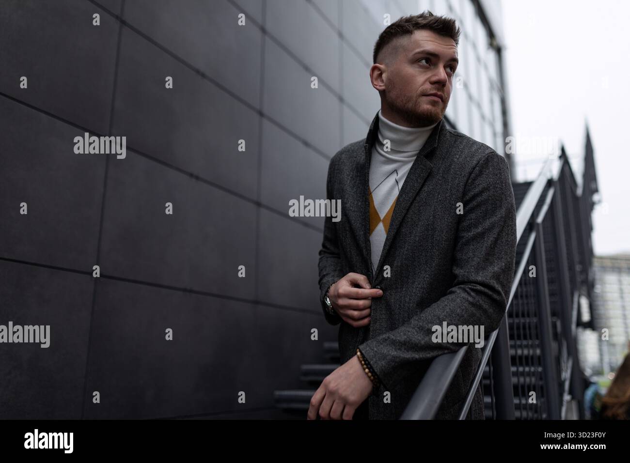 Giovane uomo brutale e alla moda con il cappotto autunnale all'aperto Foto Stock