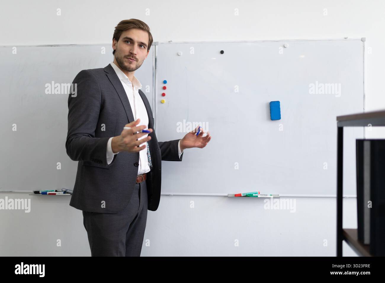 Ritratto di un lavoratore finanziario di sesso maschile che spiega la situazione dell'azienda di fronte alla lavagna Foto Stock