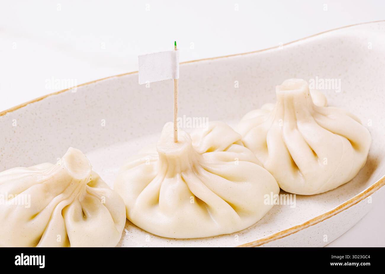 Gnocchi serviti su un piatto semplice con una piccola bandiera per l'identificazione Foto Stock