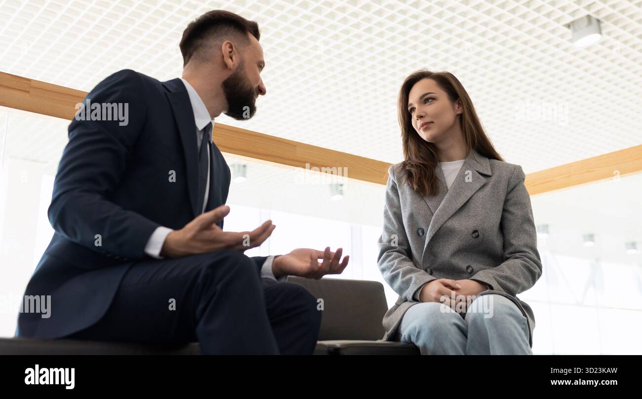 Dipendenti dell'azienda di comunicazione colleghi uomini e donne seduti sul divano, il concetto di interazione tra un cliente e un Foto Stock
