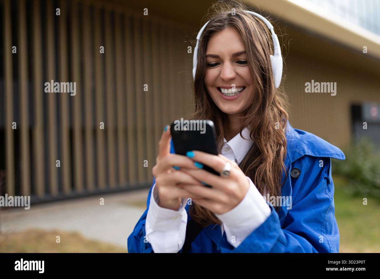 Giovane donna carismatica con un ampio sorriso in cuffie per telefono Foto Stock