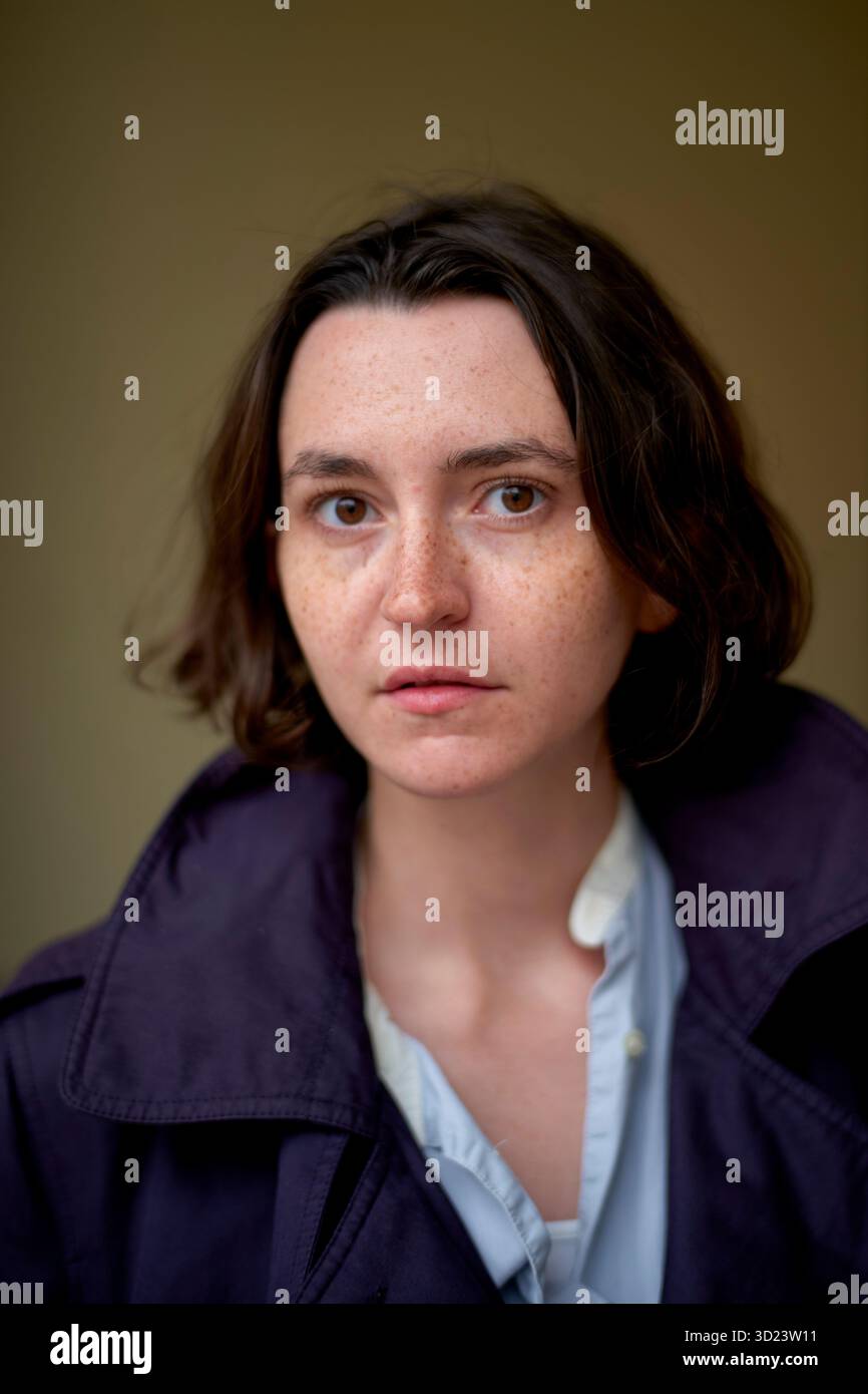 Giovane donna con i capelli corti che indossa un cappotto scuro, che guarda direttamente la fotocamera. Bruxelles, Belgio Foto Stock