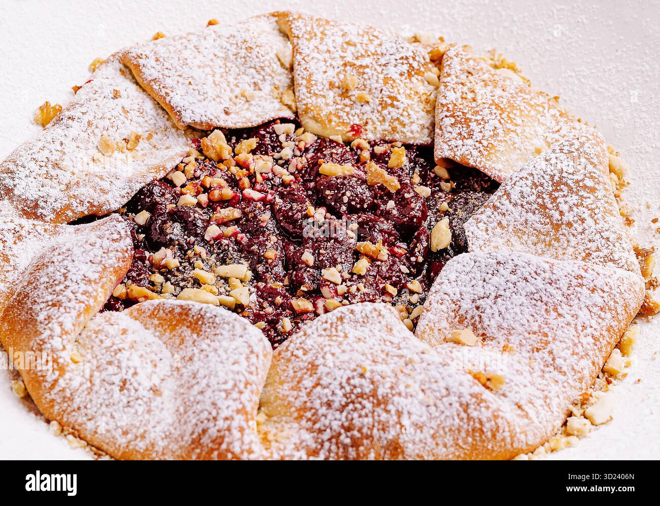 Dessert appena sfornato con noci e zucchero a velo su un piatto delicato Foto Stock