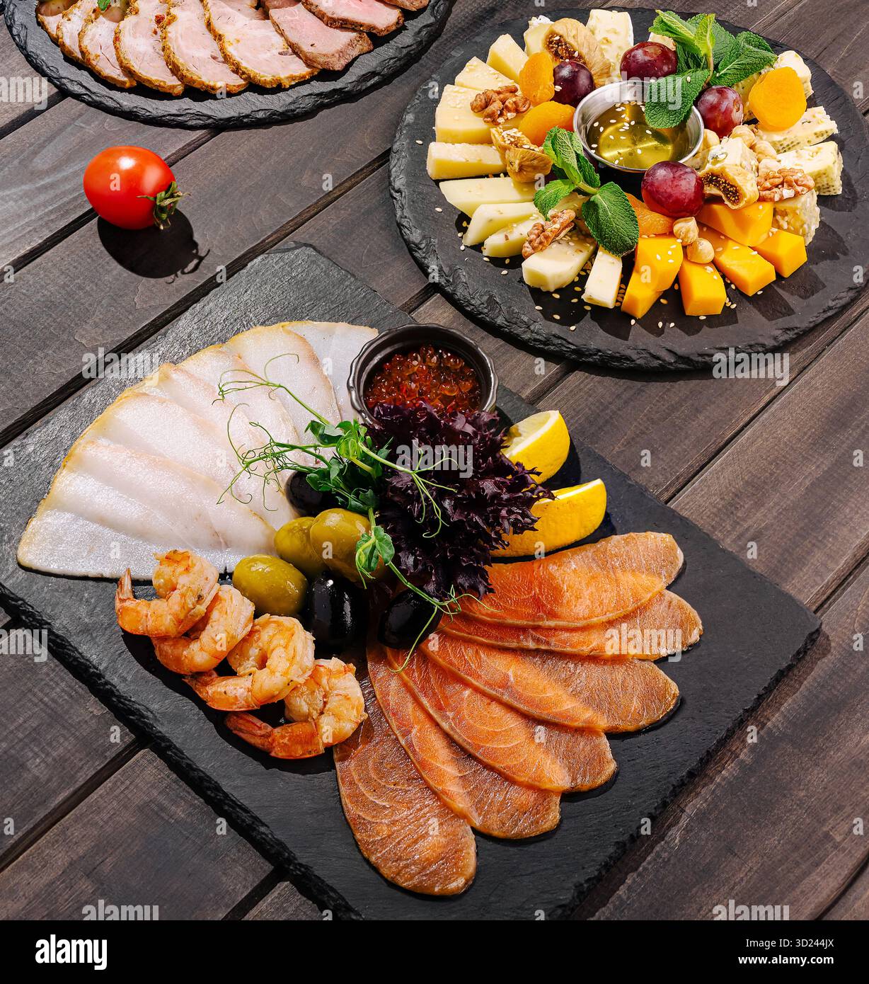 Piatto gourmet di salumi e pesce servito su tavola di ardesia Foto Stock