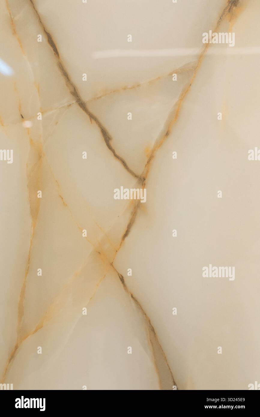 Elegante superficie in marmo beige con sorprendenti venature dorate e motivi unici che mostrano bellezza naturale Foto Stock
