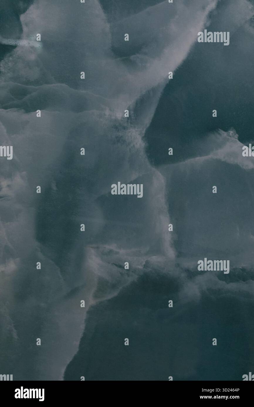 Iceberg che galleggiano nelle acque oceaniche buie durante una giornata nuvolosa nella regione artica Foto Stock