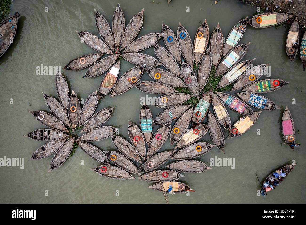Vista aerea delle barche raggruppate in un motivo floreale sull'acqua, che crea un'impressionante armonia visiva di forme e texture, Dhaka, Dhaka Division Foto Stock