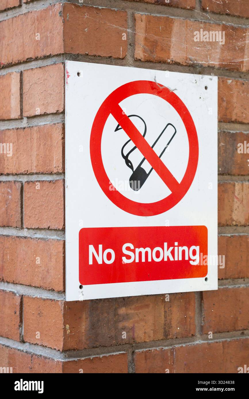 All'esterno c'è un cartello per non fumatori fissato all'angolo di un muro di mattoni. Foto Stock