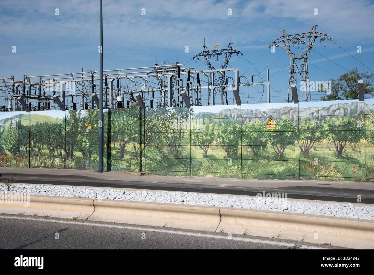 Sotto-stazione elettrica o centrale elettrica circondata da recinzione di sicurezza dipinta o muro di sicurezza con dipinti di paesaggi della Provenza in Francia Foto Stock
