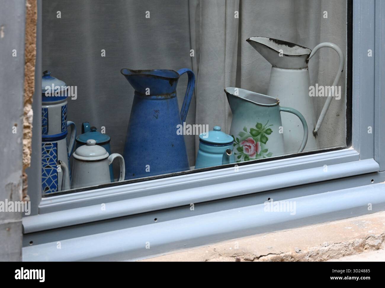 Collezione o esposizione di brocche d'acqua in stagno o peltro vintage o collezionabili nella finestra della Village House Bonnieux Provence France Foto Stock