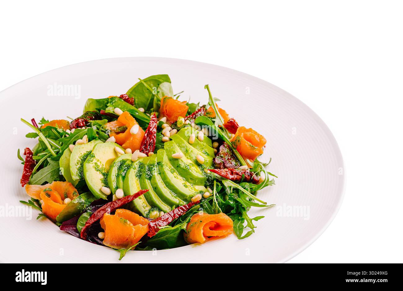 Insalata fresca con avocado, salmone affumicato e pinoli su un piatto bianco Foto Stock
