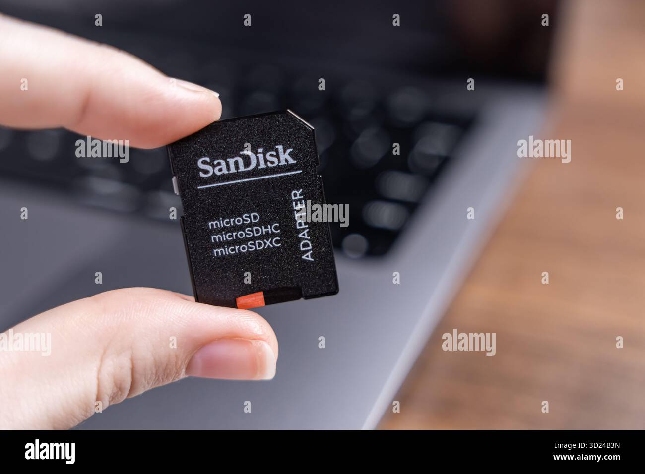 Poznan, Polonia - 18 settembre 2025: Mano che tiene in mano un adattatore digitale nero, con etichette "microSD", che evidenziano l'efficienza e la memorizzazione dei dati portatili Foto Stock