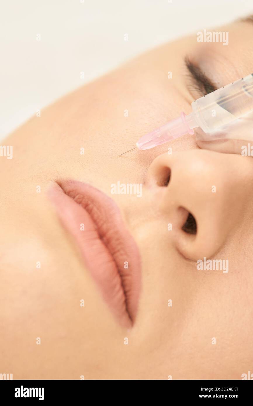 Donna che riceve un'iniezione cosmetica in vista ravvicinata della guancia Foto Stock