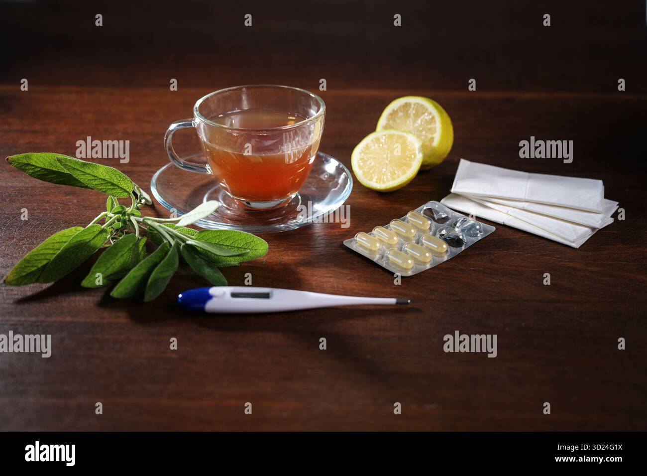 Cure domiciliari contro il raffreddore e l'influenza, come tè di salvia, limone, pillole, tessuti e un termometro di febbre su un tavolo di legno scuro, concetto di salute, c Foto Stock