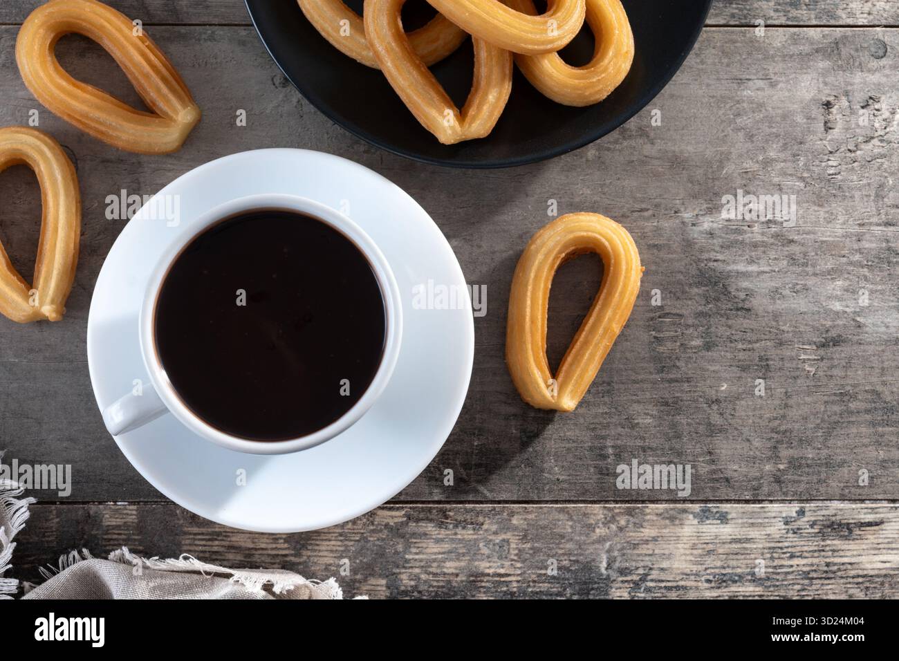 Churros spagnoli con cioccolata calda spessa in una tazza bianca su un tavolo di legno Foto Stock