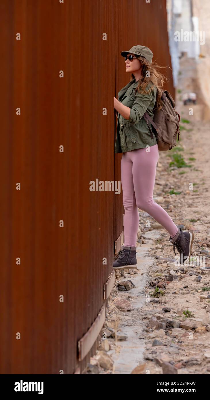 Un migrante disperato attraversa il muro di confine di Jacumba, cercando l'ingresso illegale negli Stati Uniti, evidenziando le sfide in corso in materia di immigrazione Foto Stock