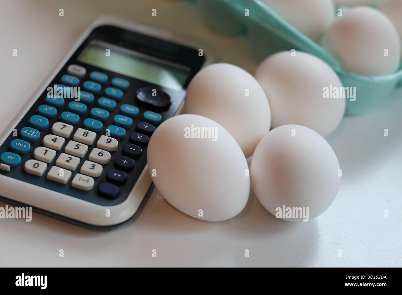 primo piano di uova sul tavolo accanto a una calcolatrice. sfondo per il tema del costo del mercato alimentare finanziario del consumatore. problemi sociali. Foto Stock