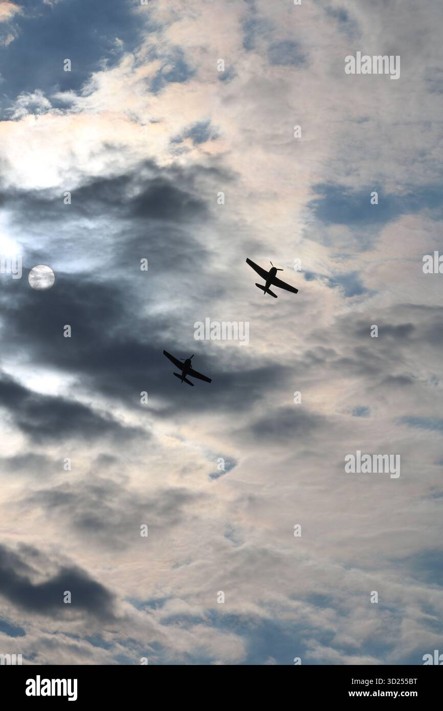 Aerei restaurati della seconda guerra mondiale che volano in cielo con nuvole e sole Foto Stock