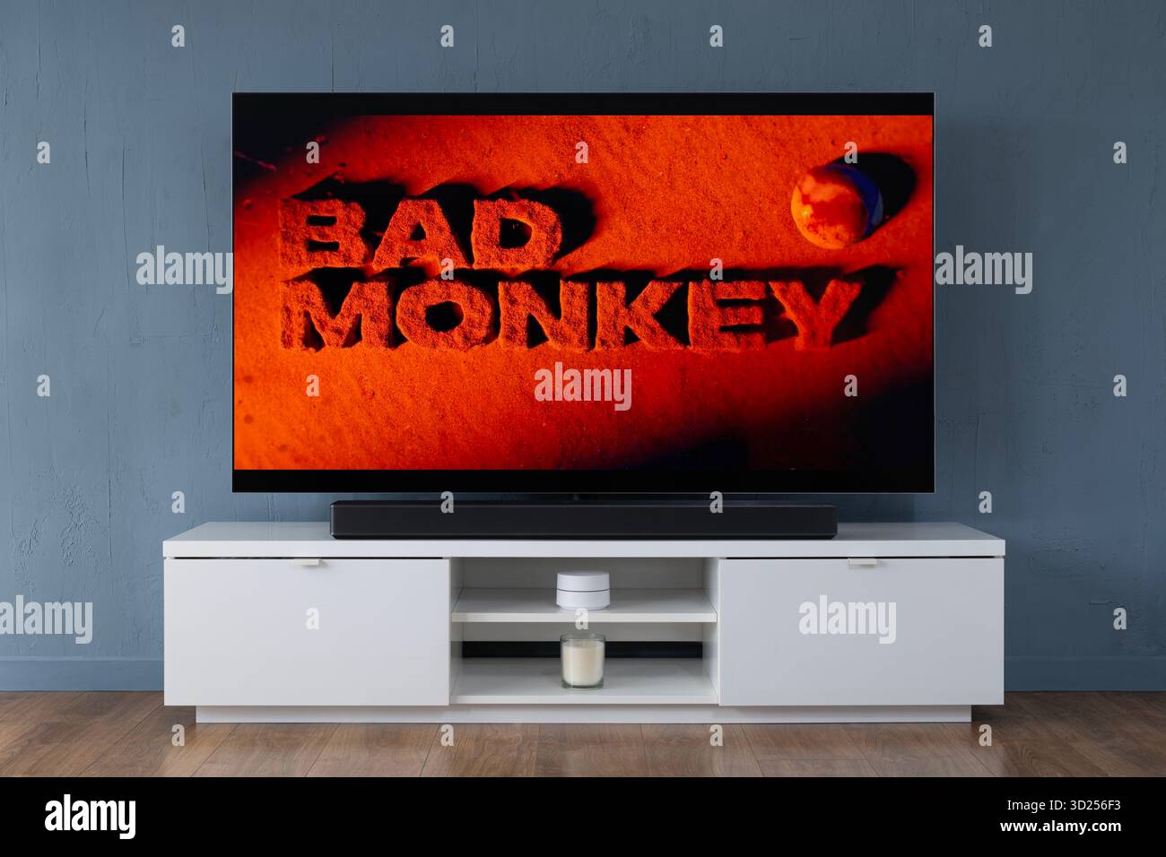 Un televisore OLED widescreen che mostra la scena introduttiva della serie TV Bad Monkey, visto in un salotto contemporaneo. Foto Stock